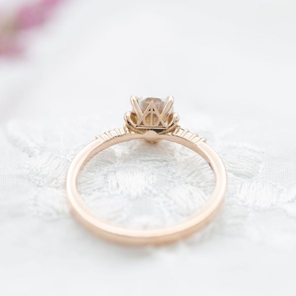 This traditionally-designed engagement ring features small nods to the deathly hallows and Beauty and the Beast’s enchanted rose.