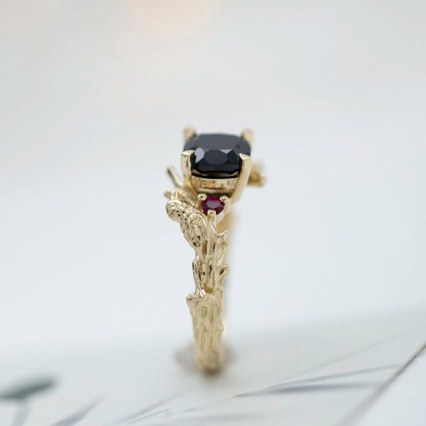 This mysterious tree themed engagement ring grows around a black spinel center stone and ruby accents.