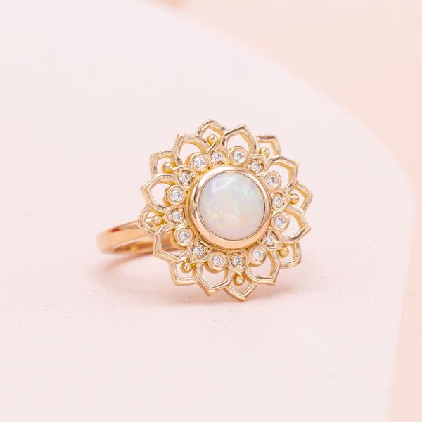 A round white opal and lab-created diamond accents are set in rose gold.