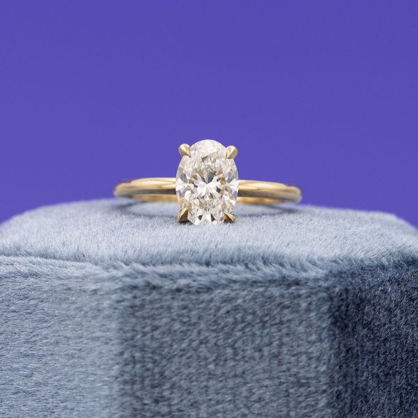 This oval lab diamond sits neatly in a yellow gold solitaire setting.