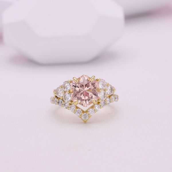 A morganite engagement ring in yellow gold with diamond accents.