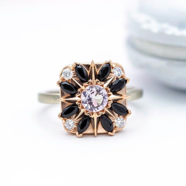 这枚装饰艺术风格的莫甘石戒指镶嵌了圆弧玫瑰，象征着佩戴者对旅行的热爱。