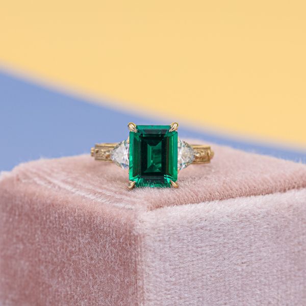 An emerald cut emerald in this celtic inspired engagement ring has a deep saturation.