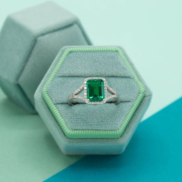 This emerald engagement ring features a split shank setting.