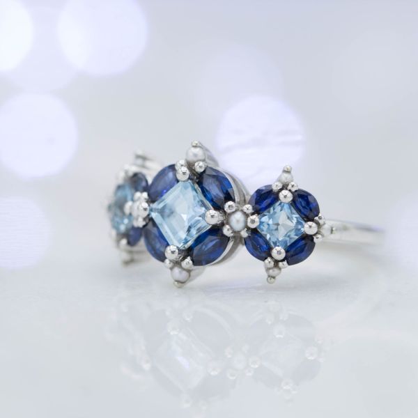 An unusual arrangement of aquamarine, sapphire, and seed pearls makes a bold, beautiful statement.