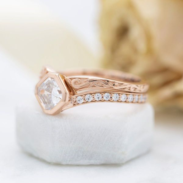This Asscher cut moissanite and rose gold engagement ring turns the solitaire rulebook on its head.
