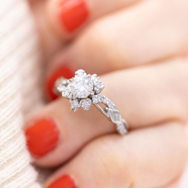 A snowfall of diamonds gently drifted onto this bridal set, as a winter flower emerges from underneath the engagement ring as thorns poke out from under the matching wedding band.