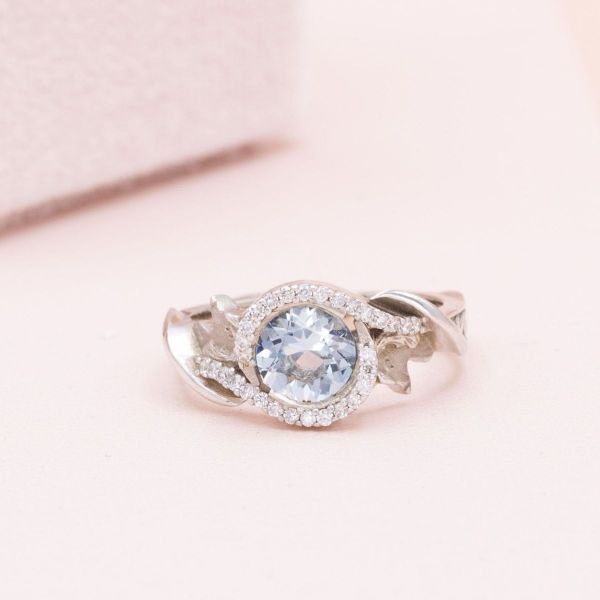 This round aquamarine is set in white gold with a diamond accent halo.