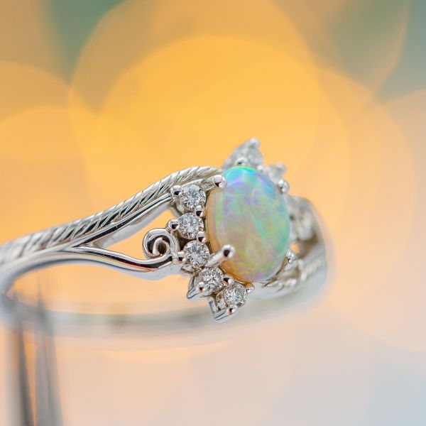 A unique, nature-inspired opal ring with a vining band and split sunburst halo.