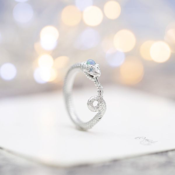 This snake inspired opal engagement ring speaks of never-ending love.