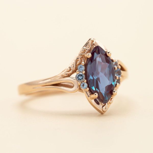 Rose gold holds this marquise cut alexandrite with touches of aquamarine accents.