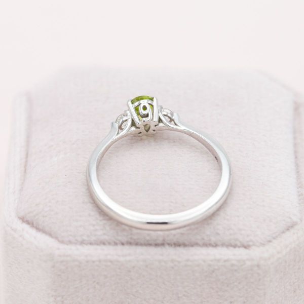 Mountain peaks are brought to life by this pear cut peridot and white topaz engagement ring.