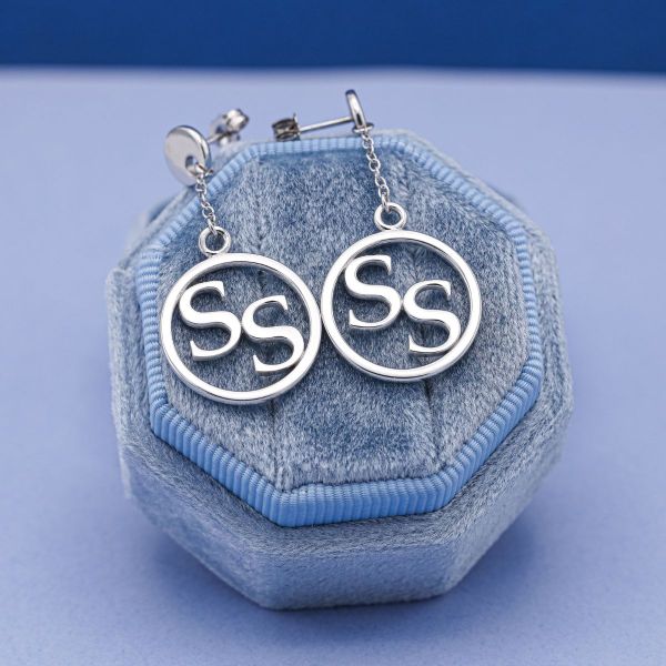 White gold earrings with SS emblem.