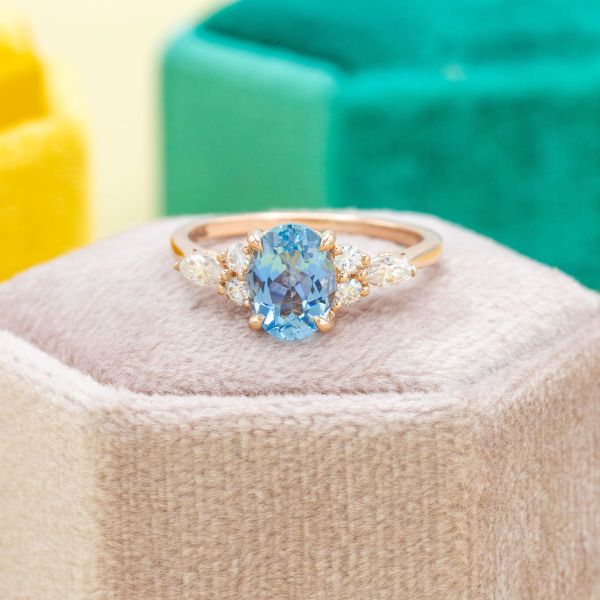 An oval aquamarine adds a pop of blue to this otherwise simplistic setting.