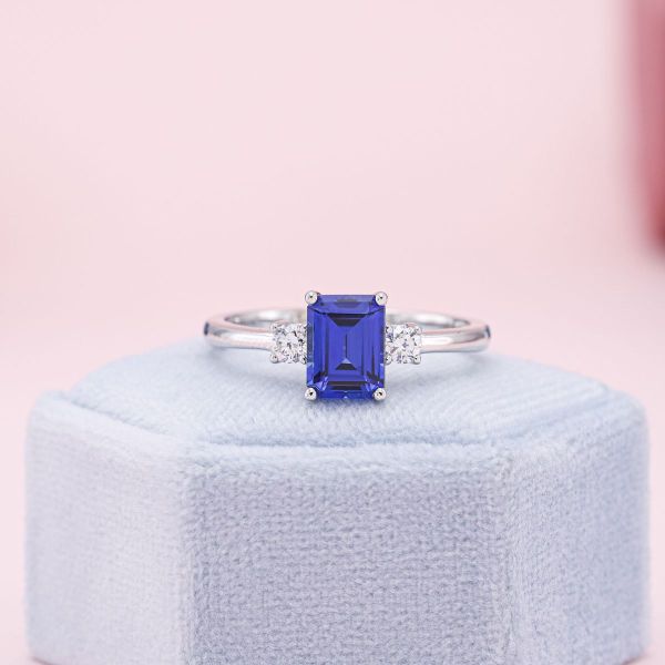 A medium blue lab sapphire engagement ring in white gold with diamond accents.